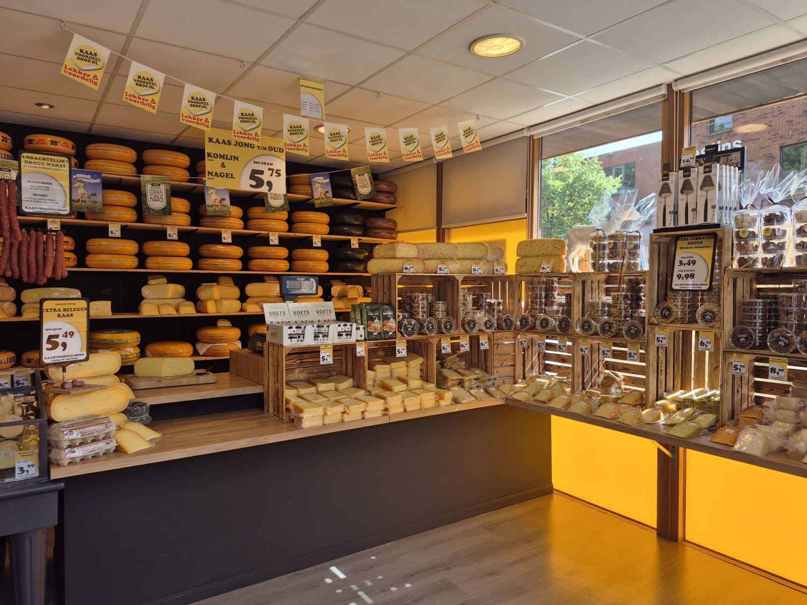 Het winkelinterieur van Kaasvoordeelshop Burgum met schappen vol Hollandse kazen, droge worst en nootjes